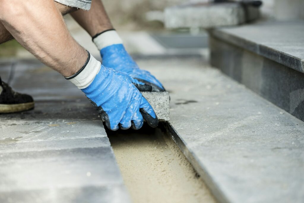 Contractor laying new paving bricks or stones